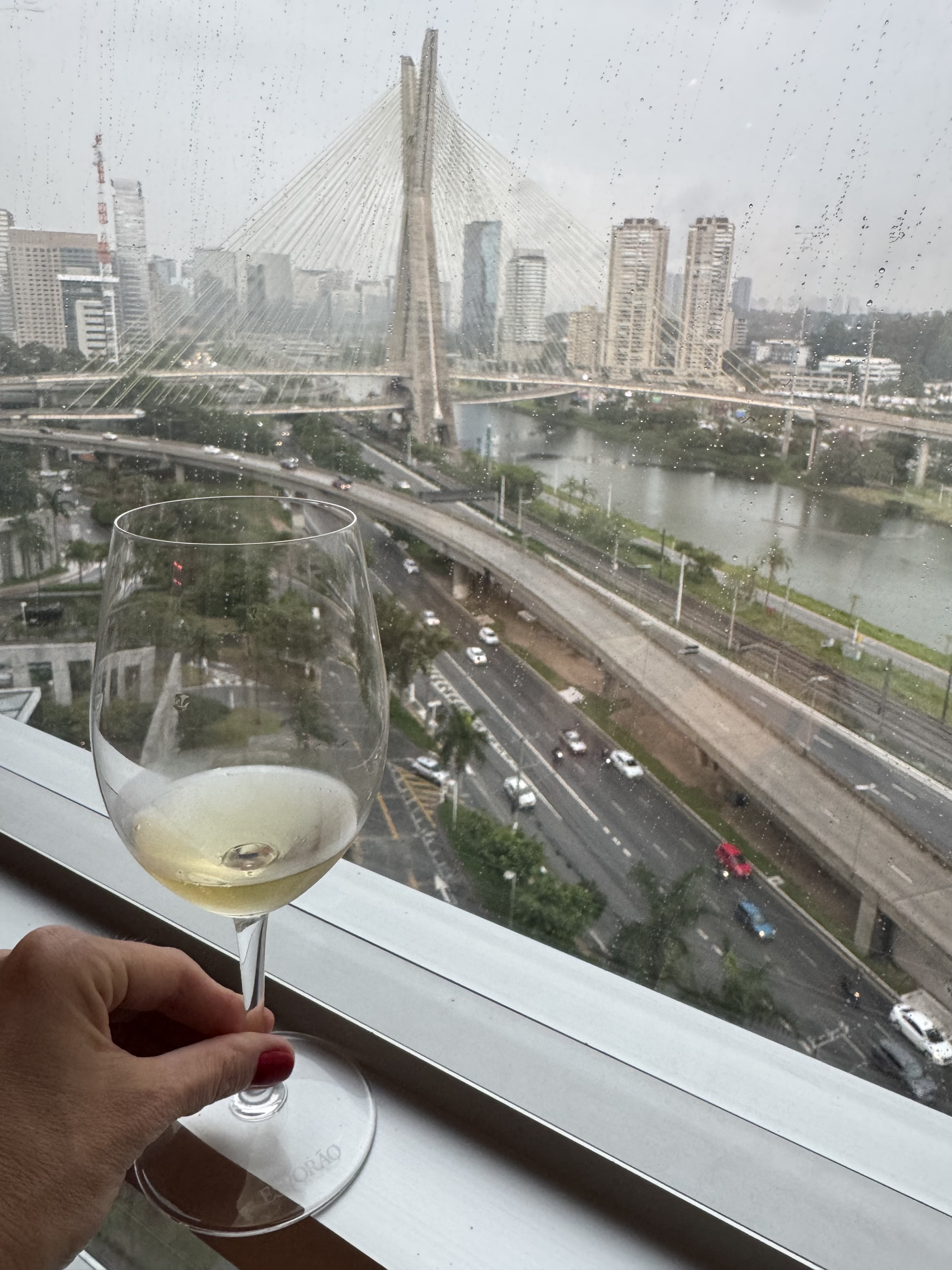 Taça de vinho branco com vista da Ponte Estaiada em São Paulo